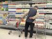 Čovek gleda u raf sa mlekom u marketu