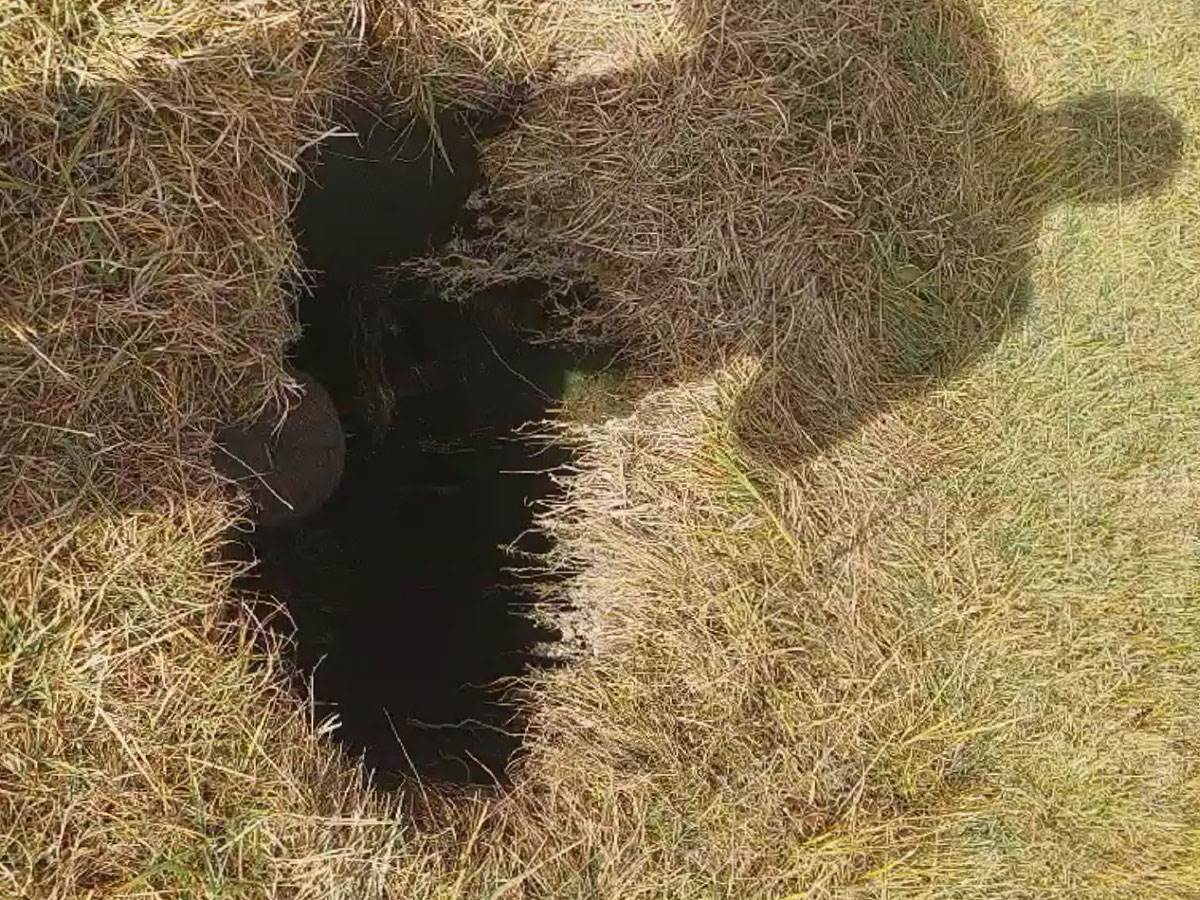 Duboka crna rupa puna vode pojavila se usred livade (4).jpg