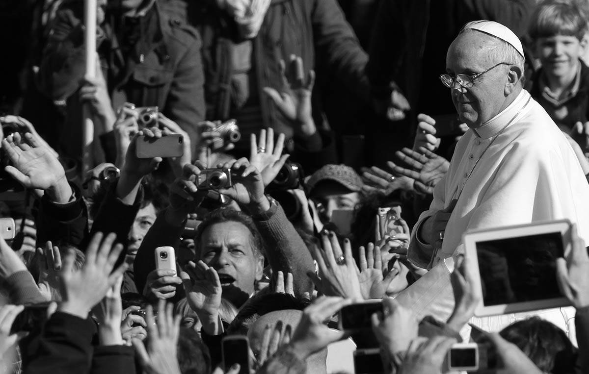 Ljudi slikaju i mašu papi Franji