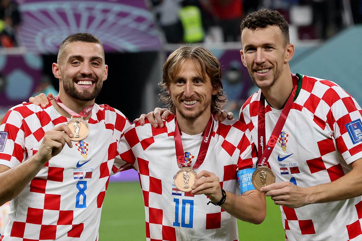 Mateo Kovačić, Luka Modrić i Ivan Perišić pokazuju bronzane medalje sa Svetskog prvenstva u Kataru.