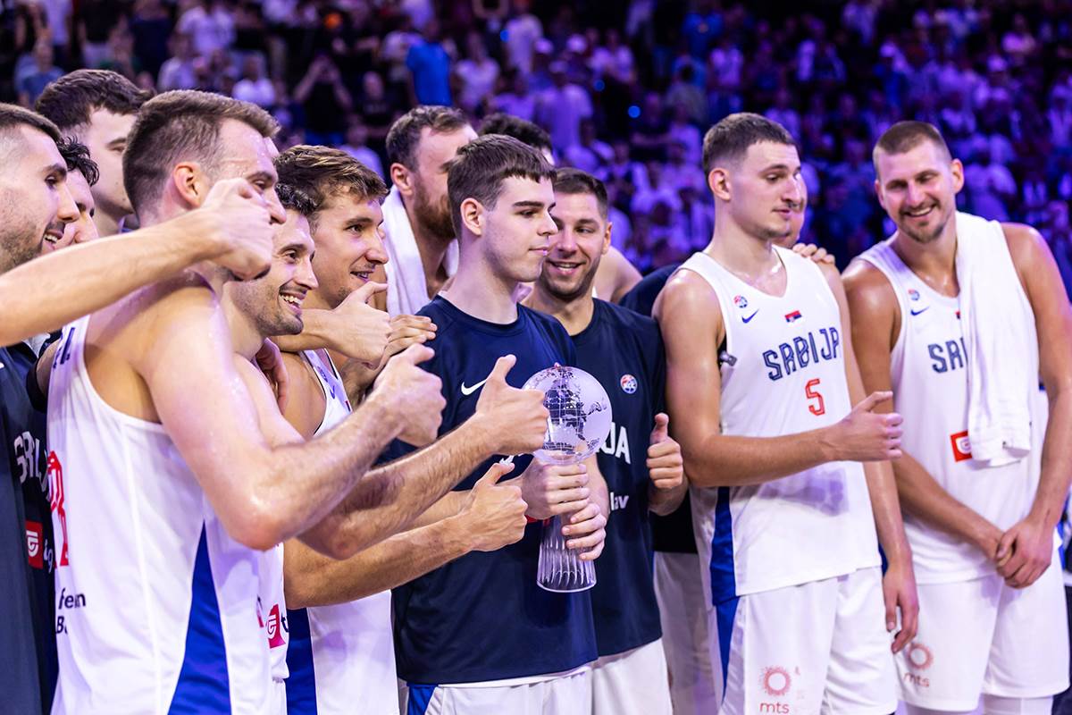 Nikola Topić drži pehar i slavi sa košarkašima Srbije.