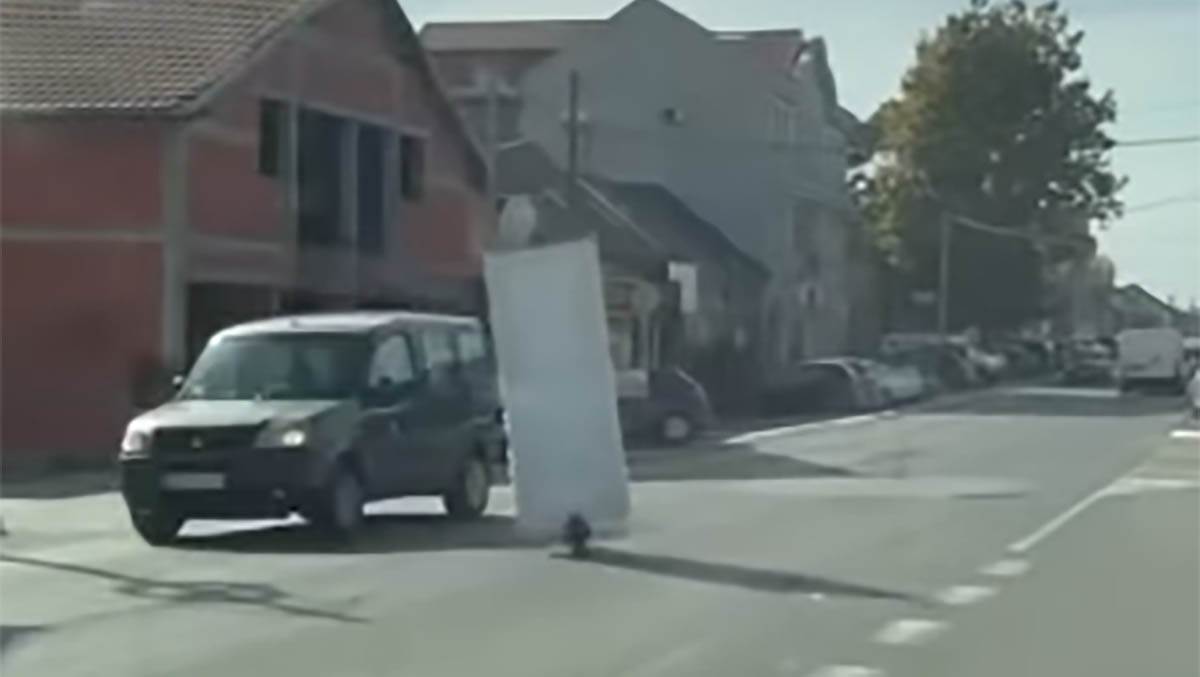 čovek vozi vrata na trotinetu kroz Surcin (3) copy.jpg