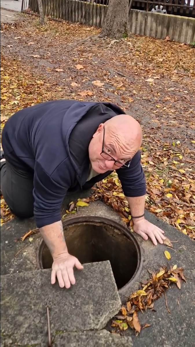 Zmijolovac Vladica Stanković vadi zmiju iz šahta u Vranju