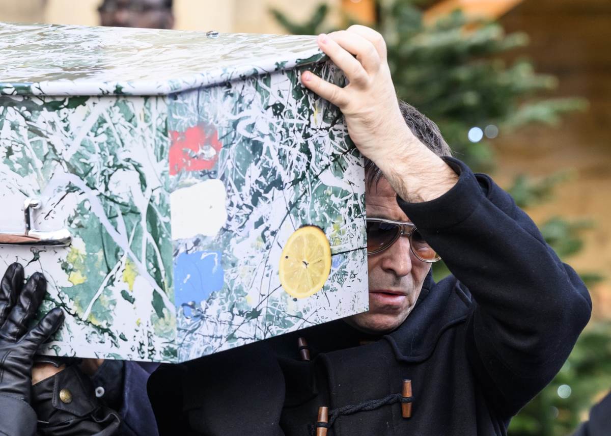 Lijam Galager nosi kovčer Manija Garija Maunfilda basiste benda Stone Roses
