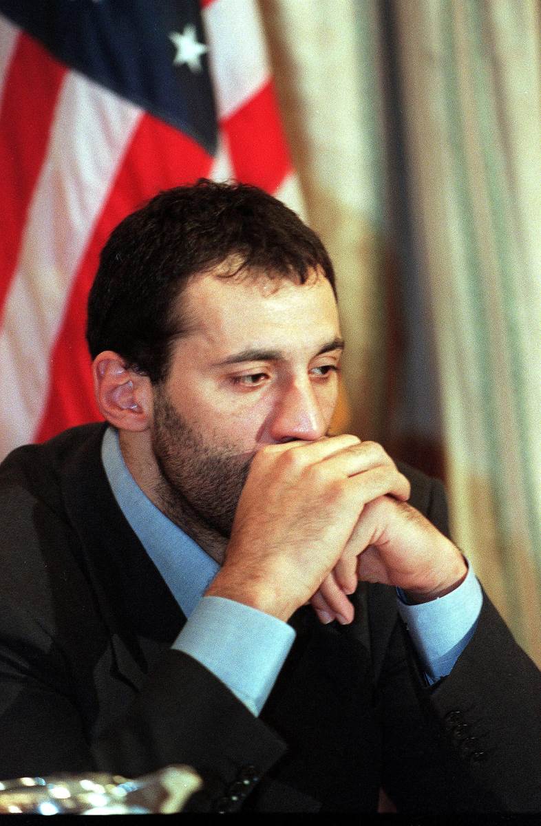 Vlade Divac sedi skrštenih ruku kraj zastave SAD.