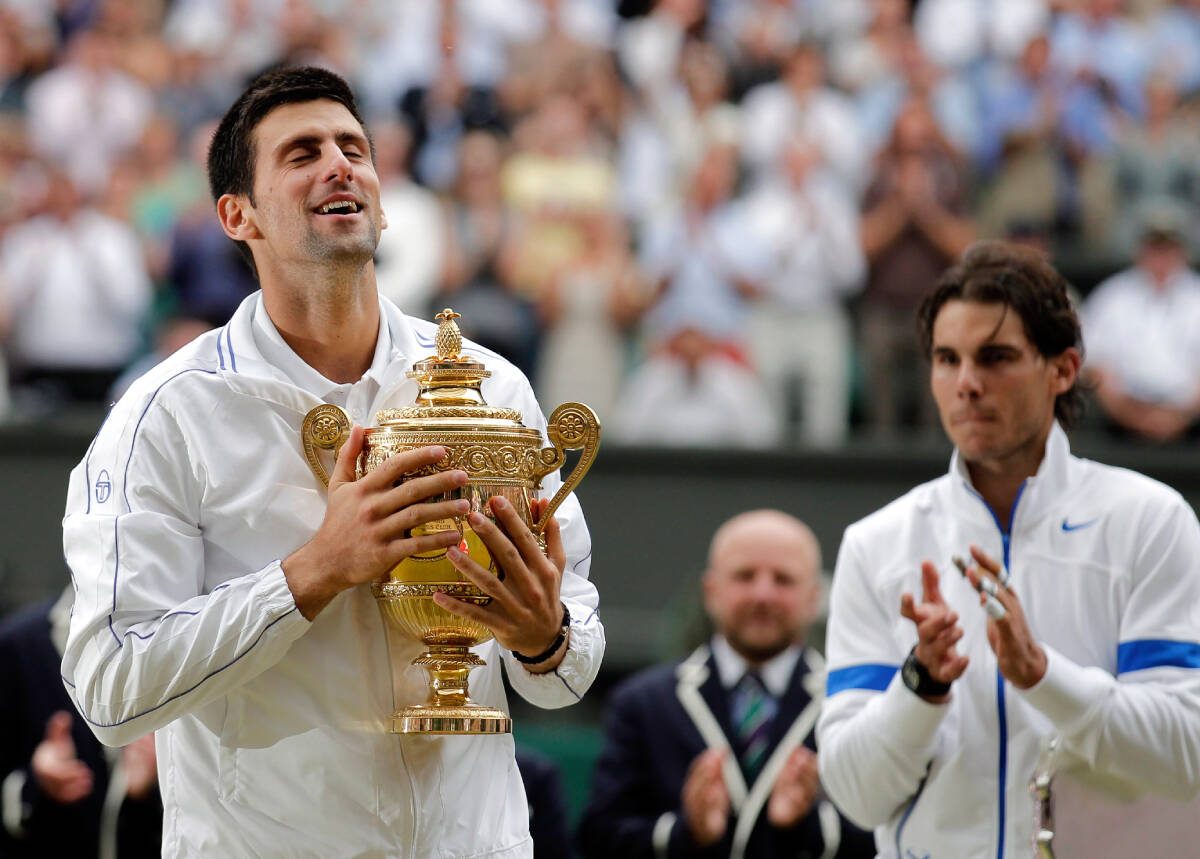 Novak Đoković podiže pehar Vimbldona kraj Rafaela Nadala. Njegov prvi, istorijski trijumf u Londonu, 2011. godine.