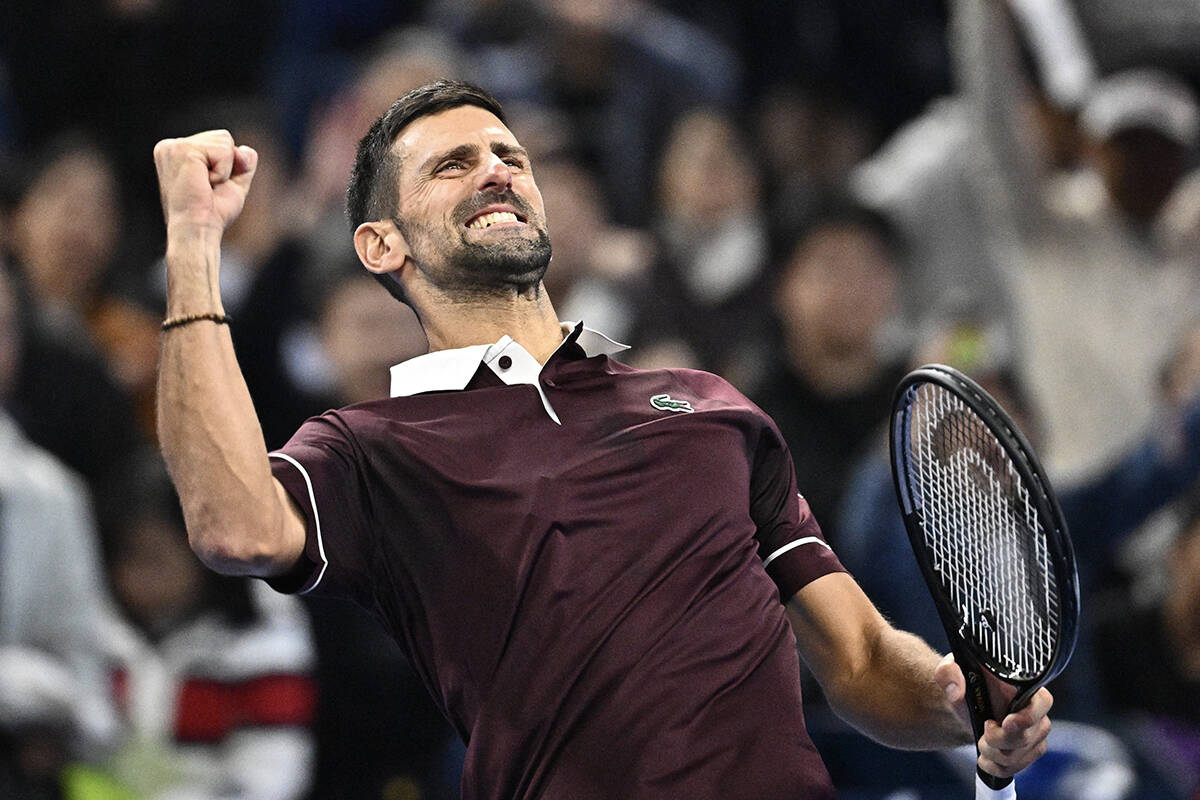 Novak Đoković slavi poen u burgundi majici u Pekingu.