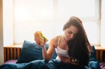 devojka jede sendvič u krevetu