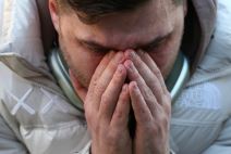 Muškarac drži ruke na licu dok plače