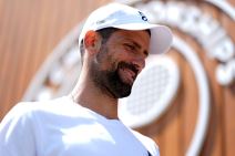 Novak Đoković nosi kačket i smeje se na Vimbldonu.