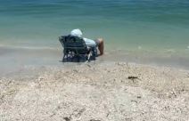 muškarac na plaži zaspao