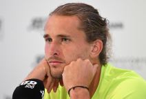 Saša Zverev se podbočio rukama na konferenciji za medije, dok nosi žutu majicu.