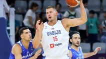 Nikola Jokić u belom dresu Srbije dobija loptu i drži je.