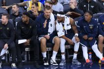 Nikola Jokić priča sa košarkašima Denvera na klupi.