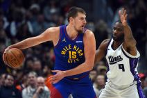 Nikola Jokić drži loptu i igra protiv Prešsa Ačuve koji mu je podigao ruku pred očima.