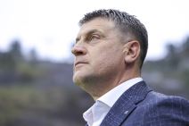 Vladan Milojević u odelu gleda zamišljeno.