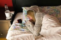 Žena leži u krevetu sa maramicom u rukama