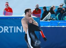 Bendžamin Karl se oblači tokom slavlja na ZOI 2026