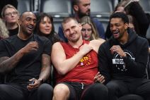 Nikola Jokić u crvenoj majici se smeje.