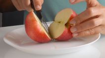 Žena seče jabuku na tanjiru