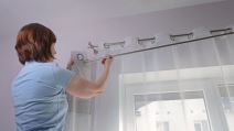Žena postavlja zavesu