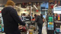 Ljudi stoje u redu na kasi u marketu