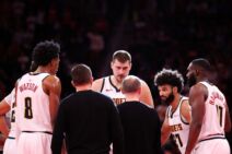 Dejvid Adelman priča sa igračima Denvera koji su oko njega, Nikola Jokić ga čudno gleda.