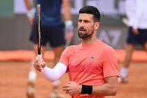 Novak Đoković u narandžastoj majici i sa belim rukavom.