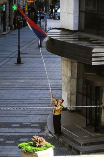 Zastava Srbije - Radnik isprvlja umotanu zastavu oko barjaka