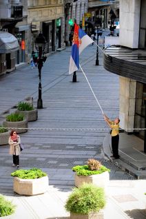 Zastava Srbije - Radnik isprvlja umotanu zastavu oko barjaka