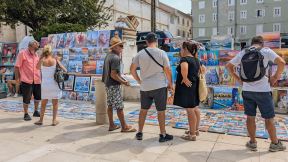 Turisti razgledaju slike uličnih prodavaca u Zadru u Hrvatskoj