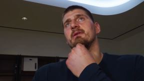 Nikola Jokić razmišlja, drži šaku na bradi.