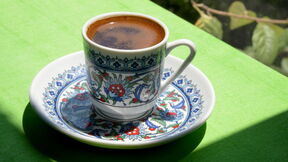 Šoljica kafe na zelenom stolu