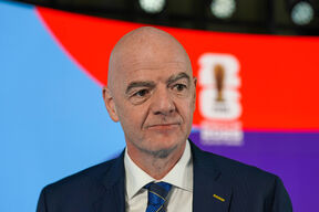 Đani Infantino u odelu sa crveno-plavom pozadinom.