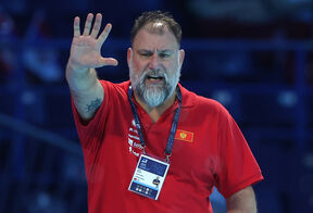 Dejan Savić diže ruku u crvenoj majici.