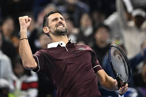 Novak Đoković slavi poen u burgundi majici u Pekingu.