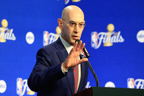Adam Silver pokazuje rukom tokom obraćanja za govornicom.