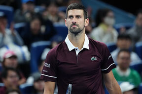 Novak Đoković u burgundi majici na turniru.
