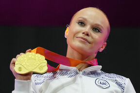 Angelina Melnikova pokazuje medalju na gimnastičarskom takmičenju