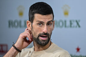 Novak Đoković se češe iza uveta u bež majici.