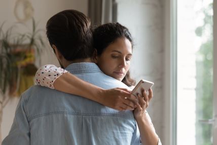 žena gleda telefon mužu iza leđa