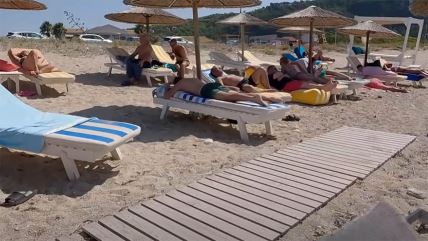 Turisti se sunčaju na ležaljkama na moru