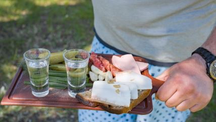 Dve čašice rakije i predjelo od masti, crnog luka, belog luka i suhomesnatog