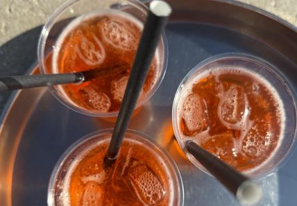 Tri koktela u plastičnim čašama sa slamčicama na ajnceru