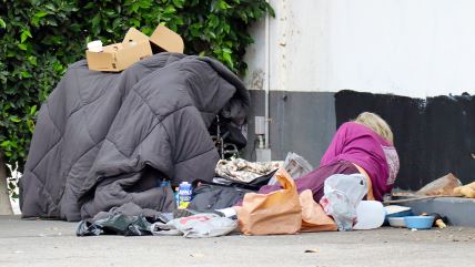 Beskućnica leži na ulici Los Anđelesa u Kaliforniji okružena smećem