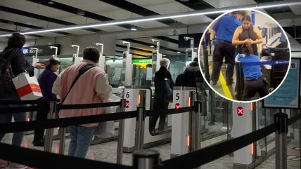 Putnici u redu na aerodromu i službenici koji proveravaju putnicu