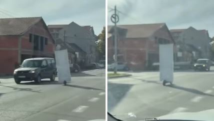 čovek vozi vrata na trotinetu kroz Surčin