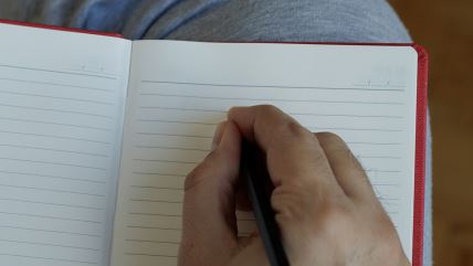 Ruka piše olovkom u svesku