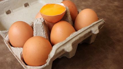 Šest jaja u kartonskoj kutiji i jedno razbijeno jaje sa žumancetom