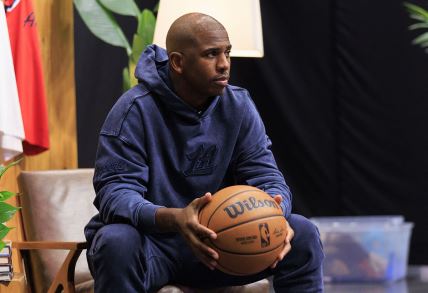 Kris Pol s loptom dok sedi u trenerci.